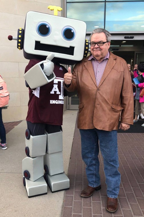 Truman Bell standing to the right of the Spark! Mascot, both giving a thumbs up